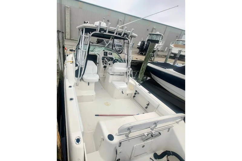 Slide: The Image of 2005 Robalo R265 Walkaround boat docked, featuring spacious cockpit and seating. - 5