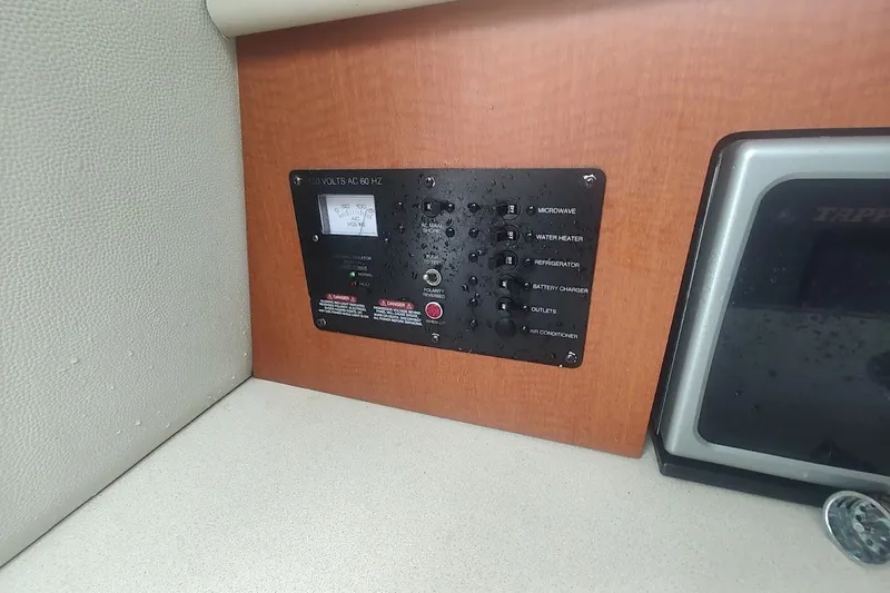 Slide: The Image of Electrical panel on 2005 Robalo R265 Walkaround boat interior, featuring various switches. - 27