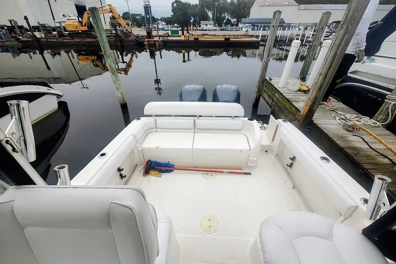 Slide: The Image of 2005 Robalo R265 Walkaround boat docked, showcasing spacious cockpit and dual outboard motors. - 15