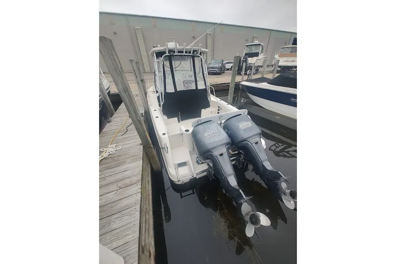 Slide: The Image of 2005 Robalo R265 Walkaround boat with twin 200 horsepower engines docked at marina. - 6