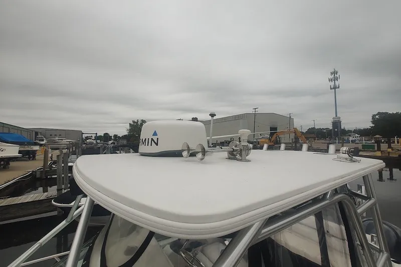 Slide: The Image of 2005 Robalo R265 Walkaround boat with Garmin radar on top, docked at marina. - 19