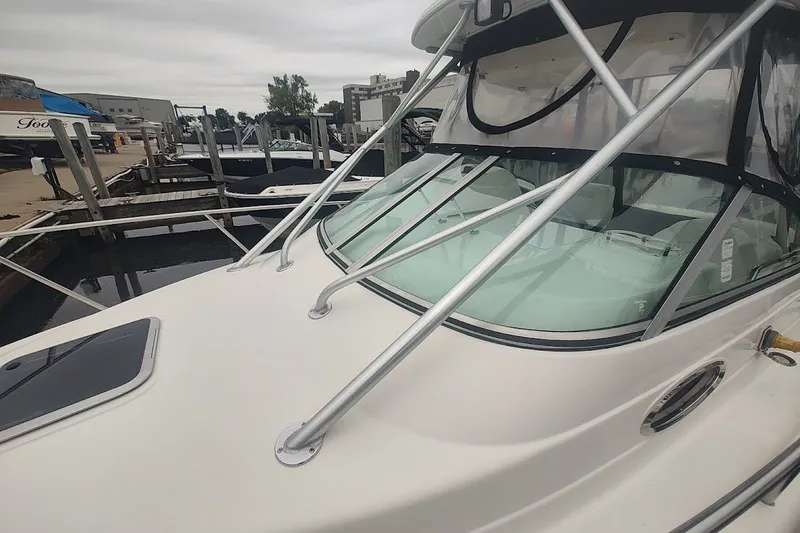 Slide: The Image of 2005 Robalo R265 Walkaround boat docked at marina, featuring sleek design and sturdy railings. - 12