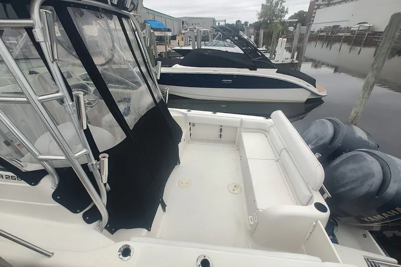 Slide: The Image of 2005 Robalo R265 Walkaround boat docked, featuring dual Yamaha engines and spacious deck area. - 20