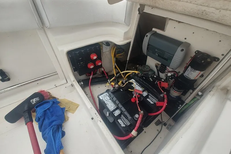 Slide: The Image of 2005 Robalo R265 Walkaround boat battery compartment with wiring and maintenance tools. - 24
