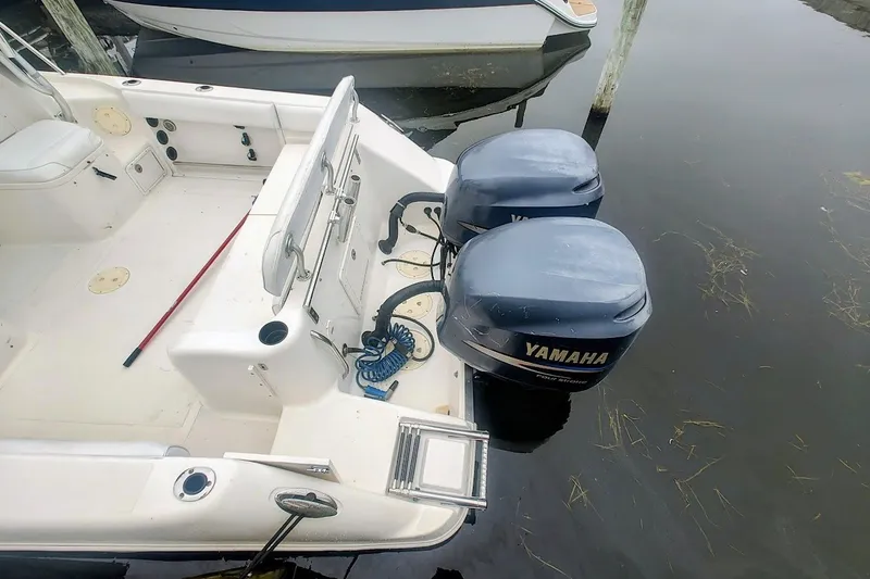 Slide: The Image of 2005 Robalo R265 Walkaround boat with twin Yamaha outboard engines docked on calm water. - 18