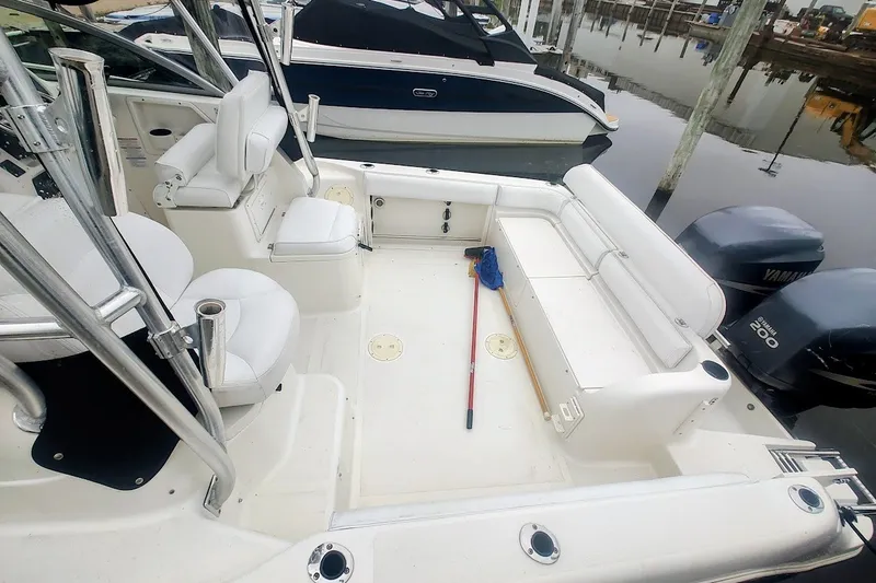 Slide: The Image of 2005 Robalo R265 Walkaround boat interior with seating and Yamaha engines at dock. - 16