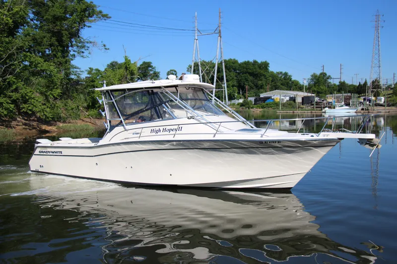 The Image of 2005 Grady-White Express 330 boat on calm water, surrounded by greenery and structures. - 0