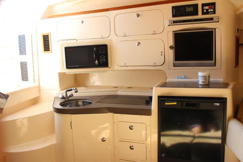 Slide: The Image of 2005 Grady-White Express 330 boat interior with kitchenette, microwave, and sink. - 12