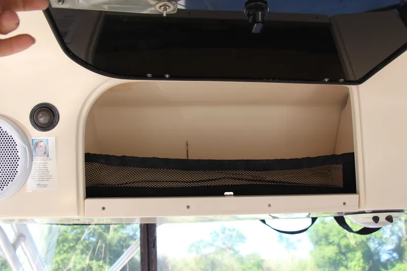 Slide: The Image of Storage compartment in a 2005 Grady-White Express 330 boat, featuring speakers and netting. - 19