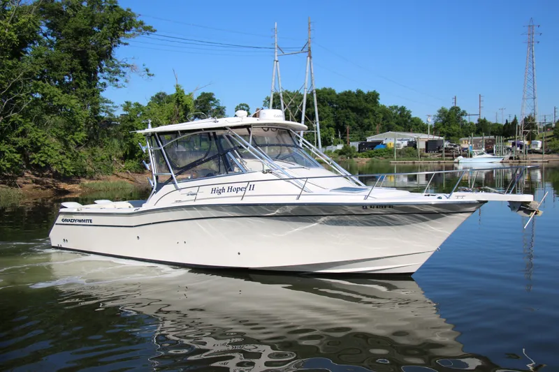 Slide: The Image of 2005 Grady-White Express 330 boat on calm water, surrounded by greenery and docks. - 2