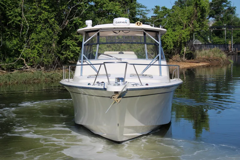 Slide: The Image of 2005 Grady-White Express 330 boat on calm water, surrounded by lush greenery. - 3