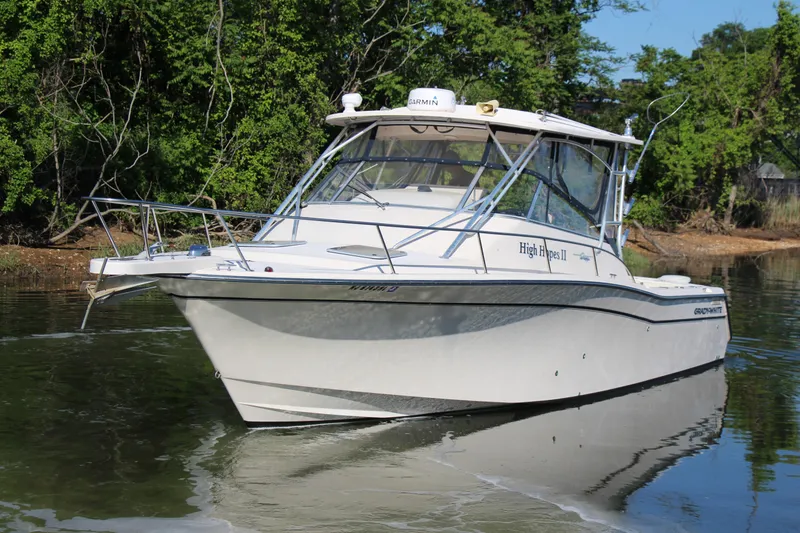 Slide: The Image of 2005 Grady-White Express 330 boat on calm water, surrounded by lush greenery. - 4