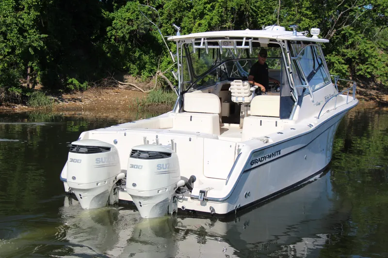Slide: The Image of 2005 Grady-White Express 330 boat with twin Suzuki engines on a calm lake. - 7