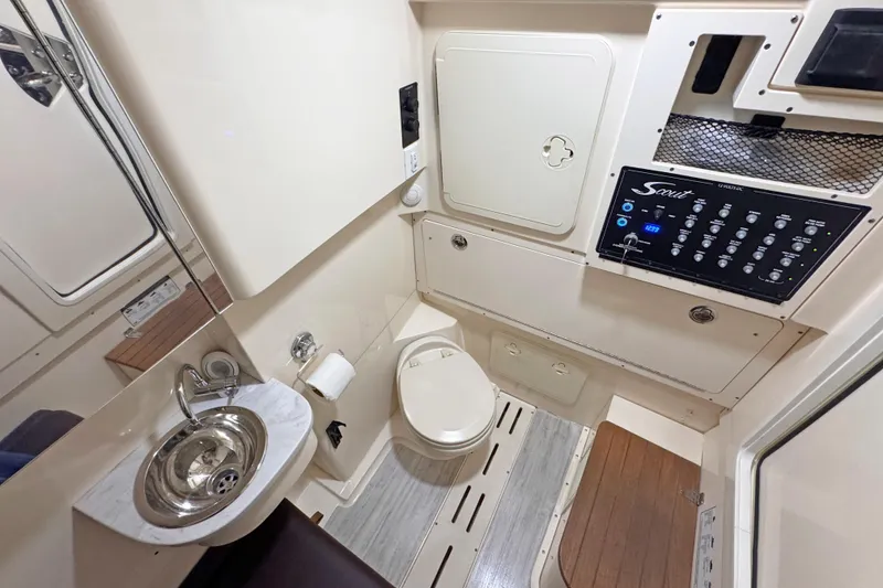 Slide: The Image of 2021 Scout 305 LXF boat interior with compact bathroom and control panel. - 12