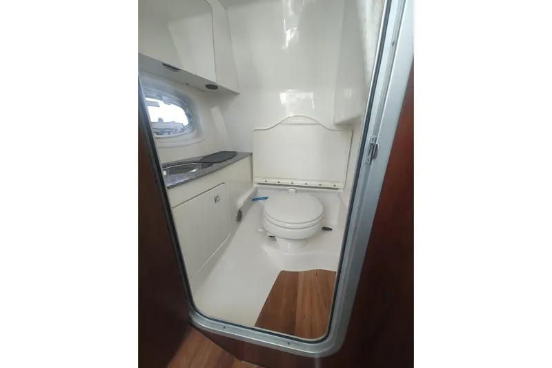 Slide: The Image of 2021 Chaparral 347 SSX boat bathroom with sink, toilet, and window. - 18