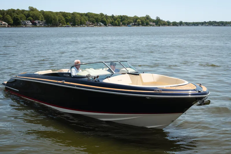 The Image of 2022 Chris Craft 34 Launch Heritage boat cruising on a serene lake. - 0