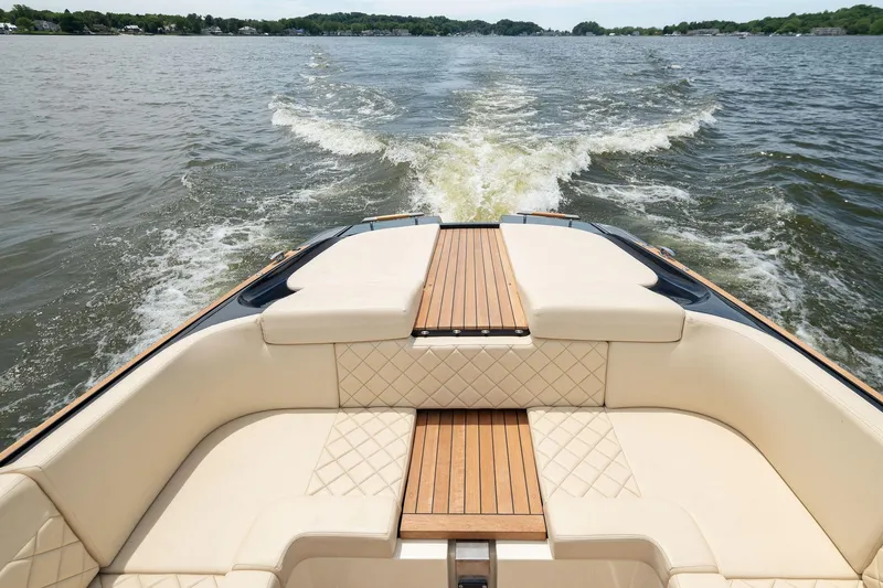 Slide: The Image of 2022 Chris Craft 34 Launch Heritage cruising on open water, showcasing luxurious seating and teak accents. - 16