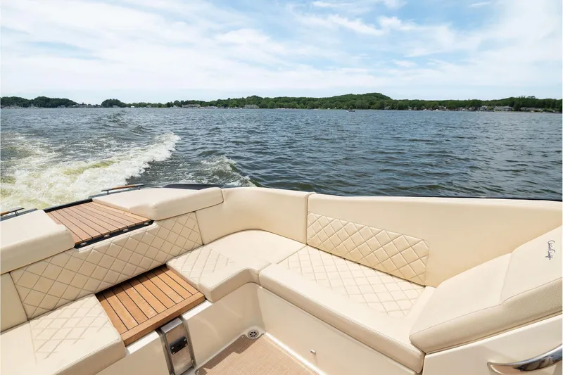 Slide: The Image of 2022 Chris Craft 34 Launch Heritage boat interior with quilted seating on a lake. - 19