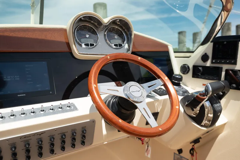 Slide: The Image of 2022 Chris Craft 34 Launch Heritage helm with wooden steering wheel and modern controls. - 24