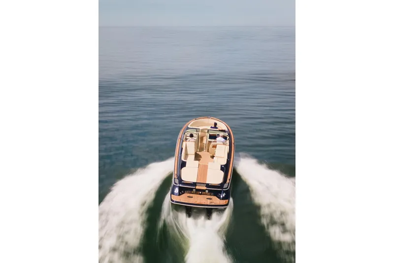 Slide: The Image of 2022 Chris Craft 34 Launch Heritage cruising on open water, aerial view. - 9