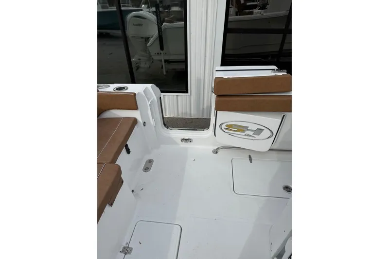 Slide: The Image of 2026 Sea Hunt Ultra 305 Coffin Box boat interior with brown seating and white deck. - 12