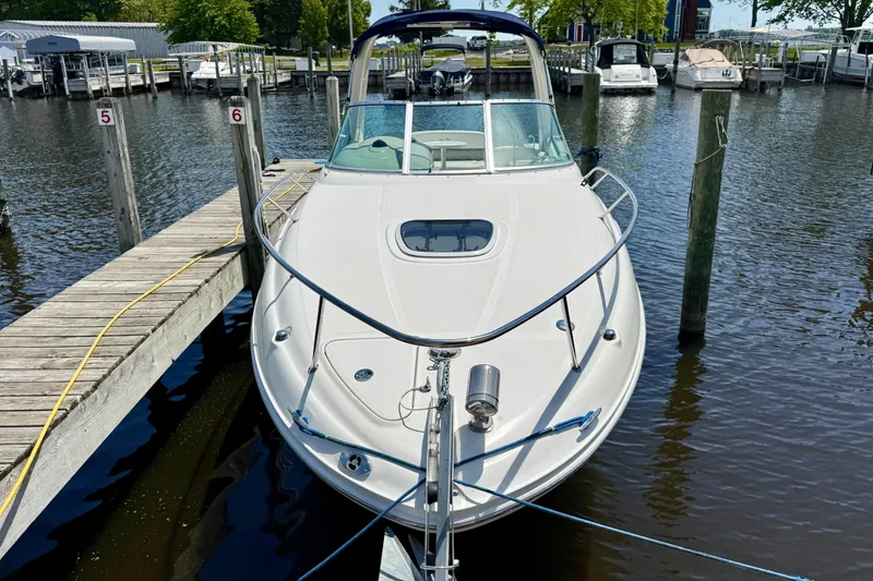 The Image of 2005 Sea Ray Sundancer 260 docked at marina, front view with calm water. - 0