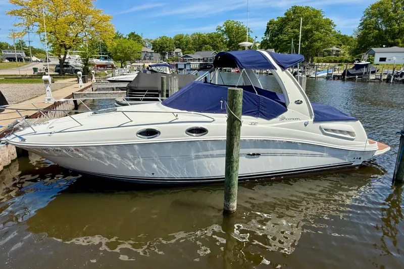 Slide: The Image of 2005 Sea Ray Sundancer 260 docked at a marina, featuring a sleek white design. - 10