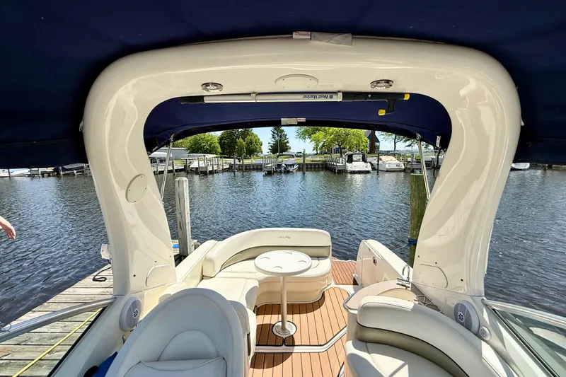 Slide: The Image of 2005 Sea Ray Sundancer 260 boat interior with seating, table, and waterfront view. - 17