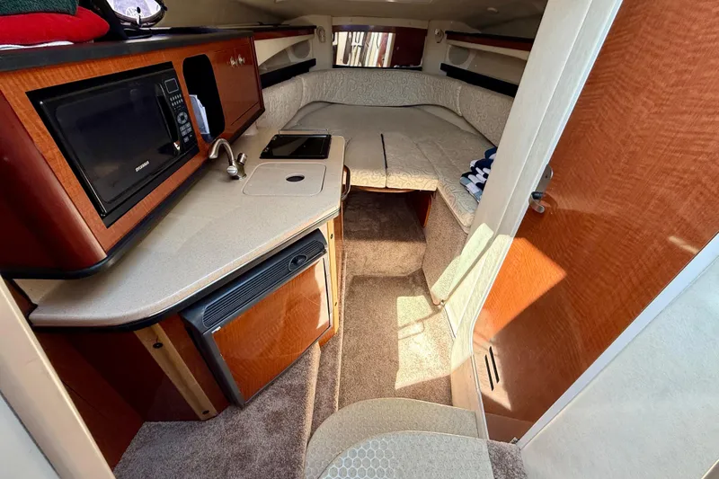 Slide: The Image of 2005 Sea Ray Sundancer 260 cabin interior with kitchenette and cozy sleeping area. - 19