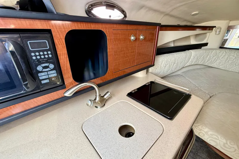 Slide: The Image of Interior of 2005 Sea Ray Sundancer 260 with kitchenette, sink, and seating area. - 21