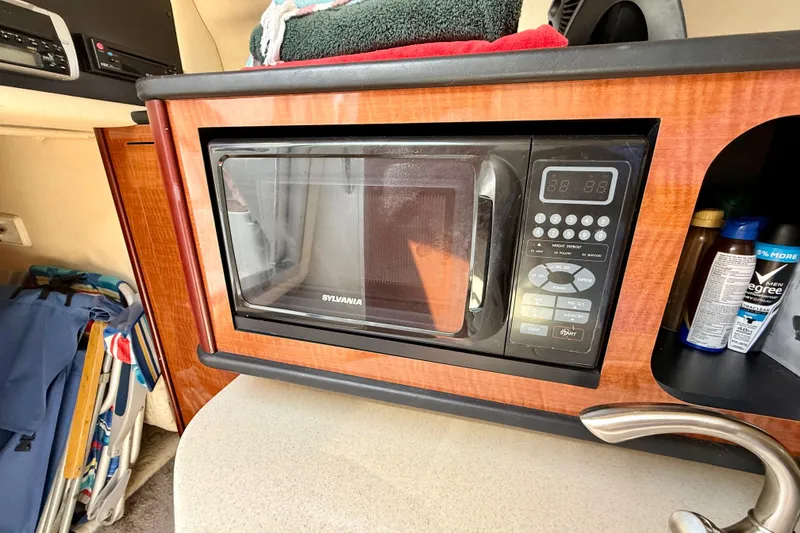 Slide: The Image of Microwave in 2005 Sea Ray Sundancer 260 cabin with wooden cabinetry and countertop. - 22