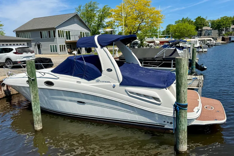 Slide: The Image of 2005 Sea Ray Sundancer 260 docked at a marina, featuring a sleek white design. - 8
