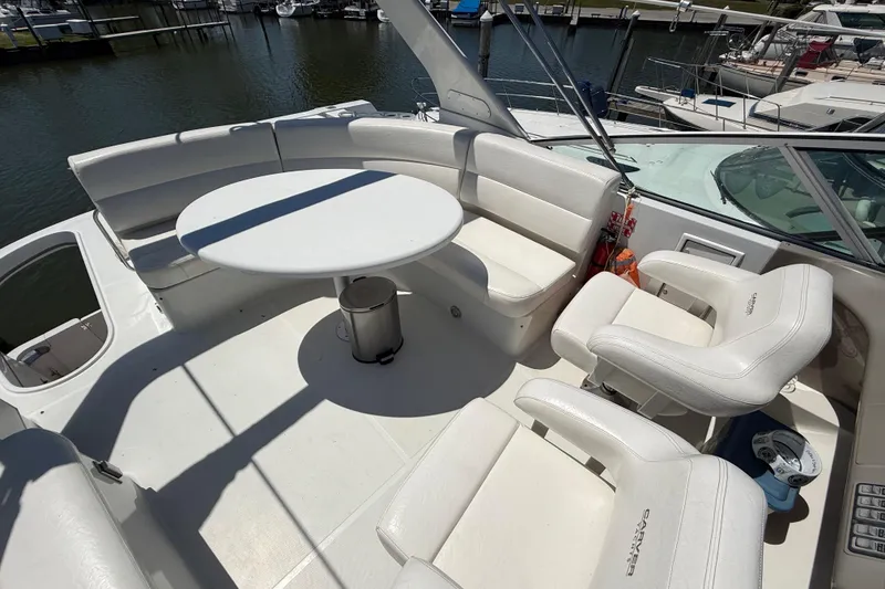 Slide: The Image of Spacious seating area on 1999 Carver 450 Voyager Pilothouse yacht, featuring white cushioned seats. - 10