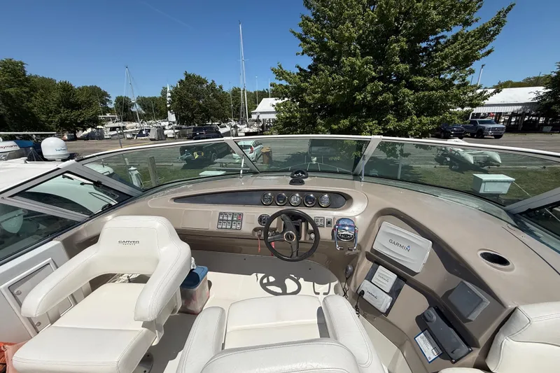 Slide: The Image of 1999 Carver 450 Voyager Pilothouse helm with steering wheel, gauges, and Garmin navigation system. - 13