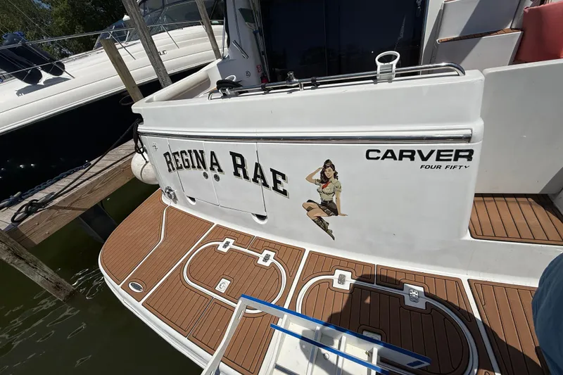 Slide: The Image of 1999 Carver 450 Voyager Pilothouse boat docked, featuring "Regina Rae" and pin-up art. - 16