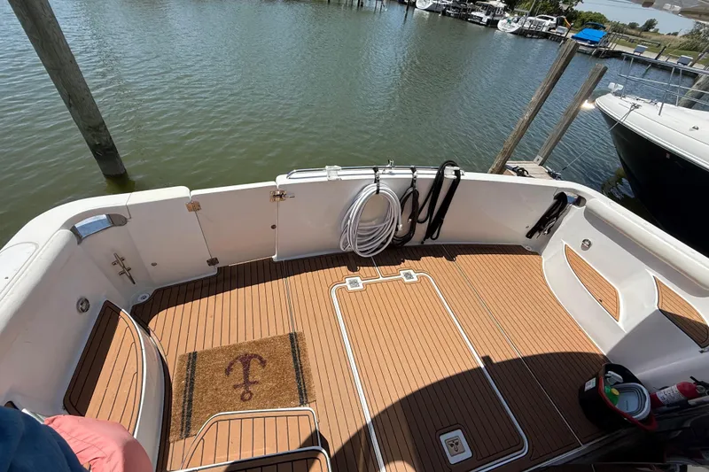 Slide: The Image of 1999 Carver 450 Voyager Pilothouse boat deck with teak flooring and dock view. - 17