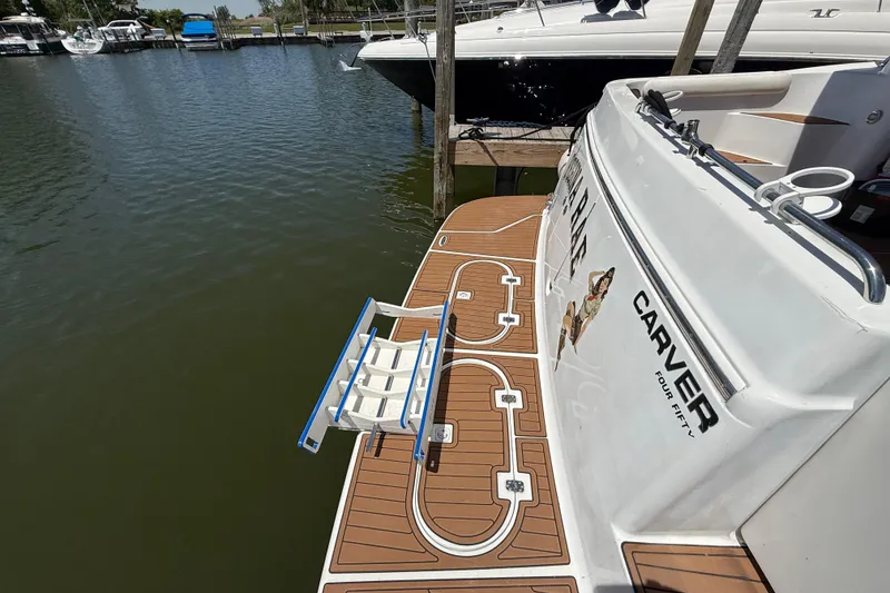 Slide: The Image of 1999 Carver 450 Voyager Pilothouse yacht with swim platform and ladder at marina. - 18
