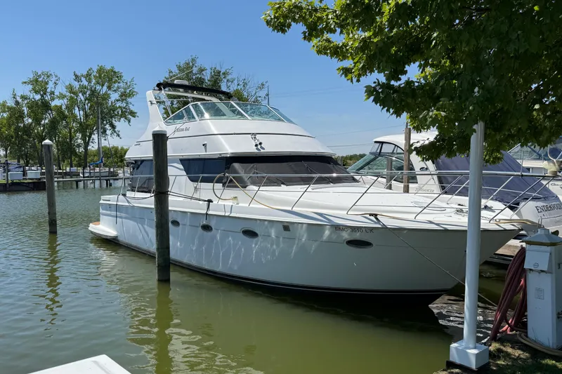 Slide: The Image of 1999 Carver 450 Voyager Pilothouse yacht docked in a serene marina setting. - 3