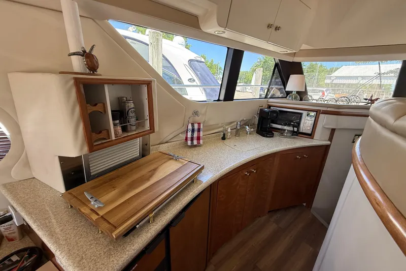 Slide: The Image of Interior of 1999 Carver 450 Voyager Pilothouse yacht kitchen with wooden cabinets and appliances. - 32