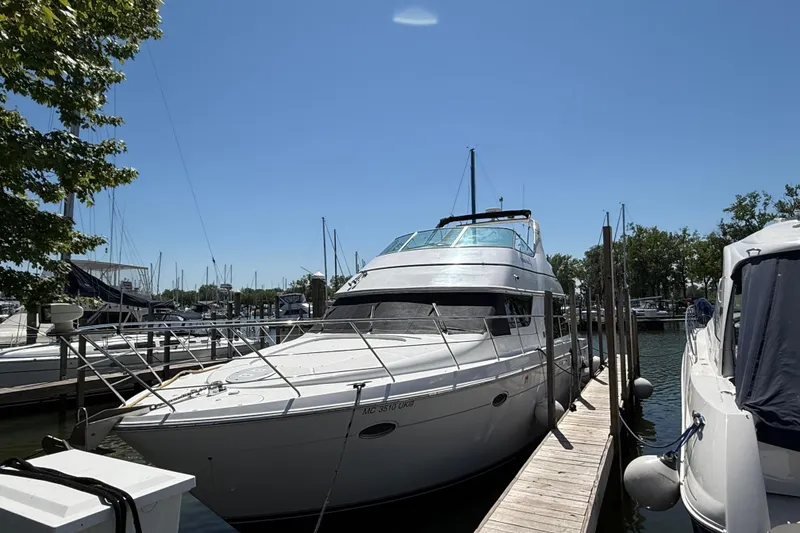Slide: The Image of 1999 Carver 450 Voyager Pilothouse yacht docked at marina under clear blue sky. - 4