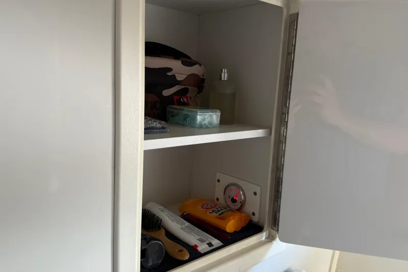 Slide: The Image of Open cabinet on 1999 Carver 450 Voyager Pilothouse with toiletries and grooming items. - 43
