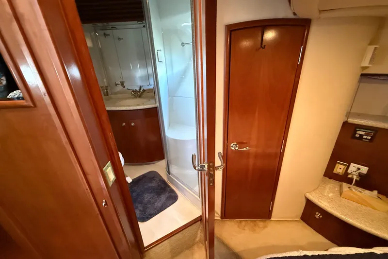 Slide: The Image of Interior of 1999 Carver 450 Voyager Pilothouse, featuring bathroom and wooden cabinetry. - 46