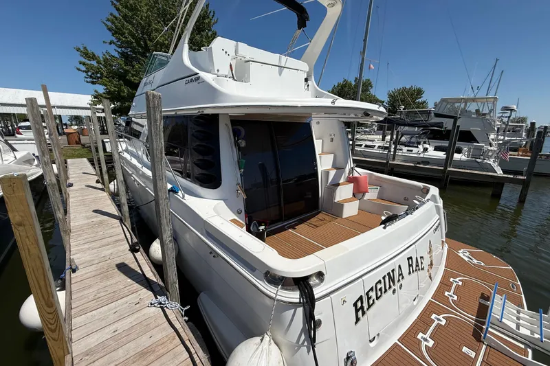 Slide: The Image of 1999 Carver 450 Voyager Pilothouse docked at marina, rear view with deck and stairs. - 5