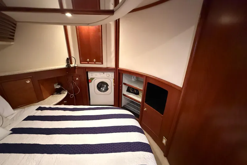 Slide: The Image of Interior of 1999 Carver 450 Voyager Pilothouse with bed, washer, and wooden cabinetry. - 50