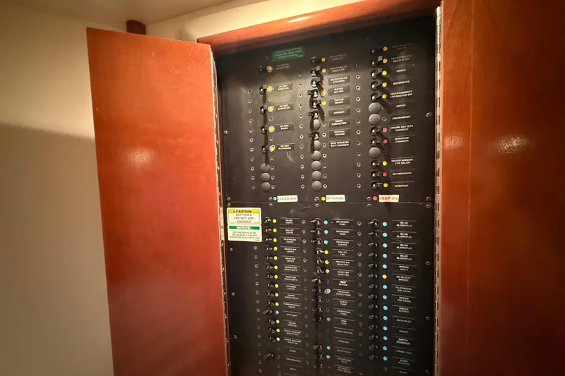 Slide: The Image of Electrical panel inside a 1999 Carver 450 Voyager Pilothouse yacht, with open wooden doors. - 51