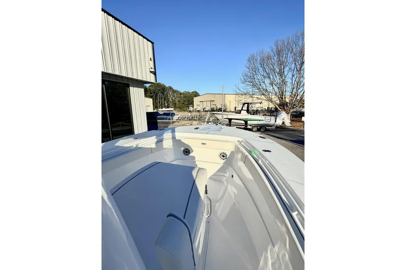 Slide: The Image of 2026 Sea Hunt Ultra 275 Coffin Box boat, side view, docked under clear blue sky. - 8