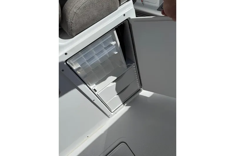 Slide: The Image of 2026 Sea Hunt Ultra 275 Coffin Box storage compartment with open door, showcasing interior space. - 13