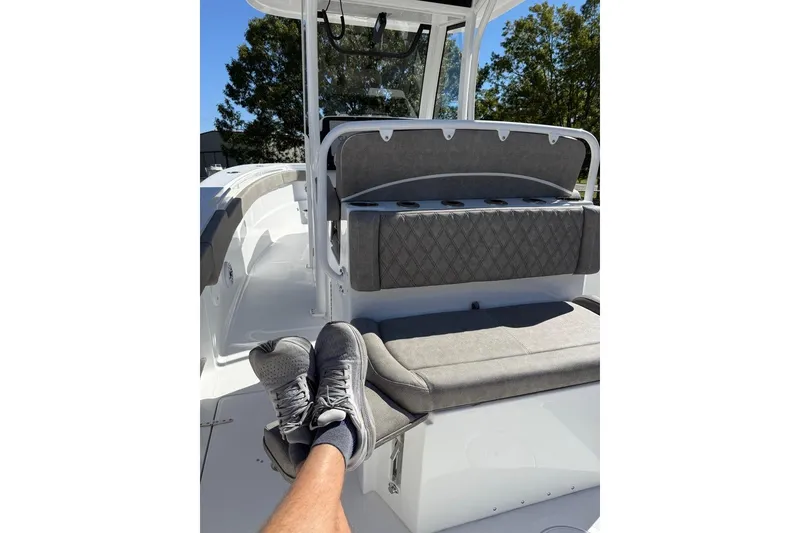 Slide: The Image of 2026 Sea Hunt Ultra 275 Coffin Box boat interior with gray seating and relaxed feet. - 26