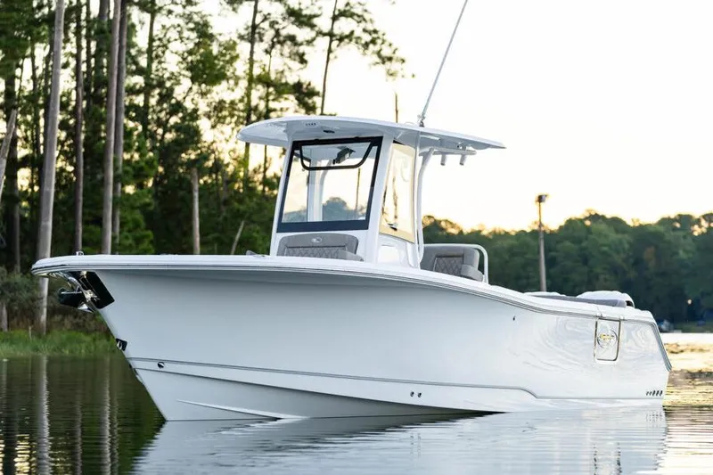 Slide: The Image of Manufacturer Provided Image: 2026 Sea Hunt Ultra 275 Coffin Box boat on calm water, surrounded by trees. - 36