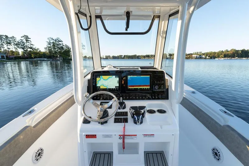 Slide: The Image of Manufacturer Provided Image: 2026 Sea Hunt Ultra 275 Coffin Box boat dashboard with navigation screens on a serene lake. - 38